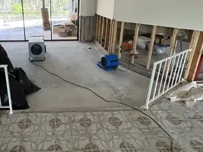 An air mover drying a room with the walls cut open above the water line